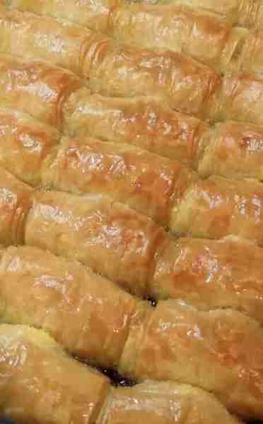 Galaktoboureko is a delicious Greek dessert made with creamy custard wrapped in layers of crispy phy...