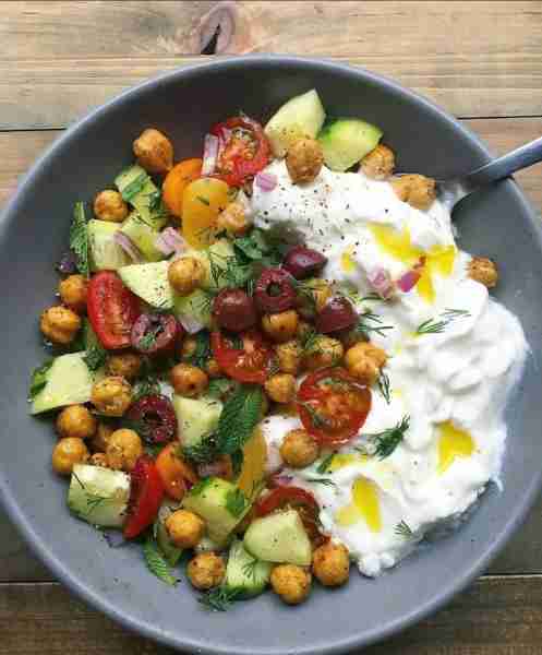 Savory yogurt bowl made with plain full fat Greek yogurt and topped with chili roasted chickpeas, to...