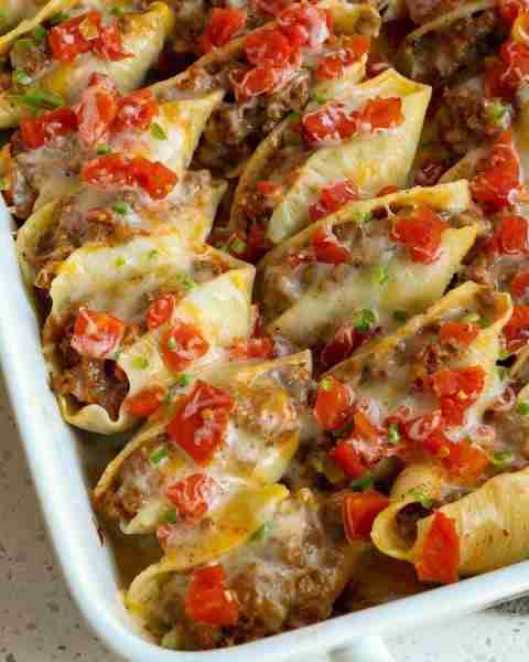 Taco Stuffed Shells are plump full of seasoned ground beef, onions, salsa, cheddar, and Monterey Jac...