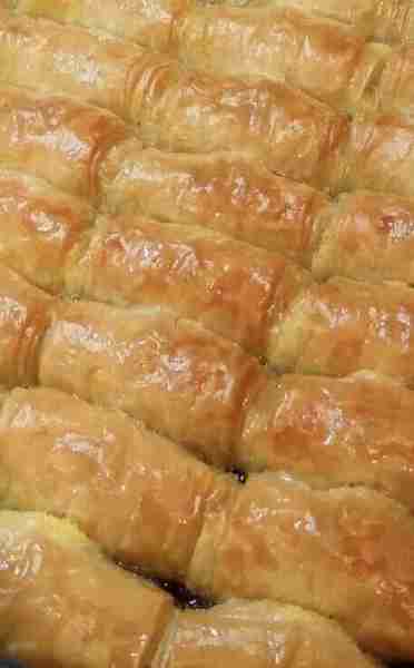 Galaktoboureko is a delicious Greek dessert made with creamy custard wrapped in layers of crispy phy...