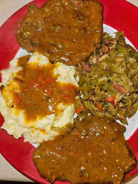 Cube steaks with gravy, homemade garlic mashed potatoes, and fried green beans with bacon, onions an...