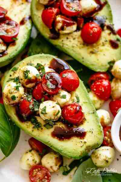 Basil pesto CAPRESE STUFFED AVOCADO drizzled with balsamic glaze makes an incredible light lunch or...