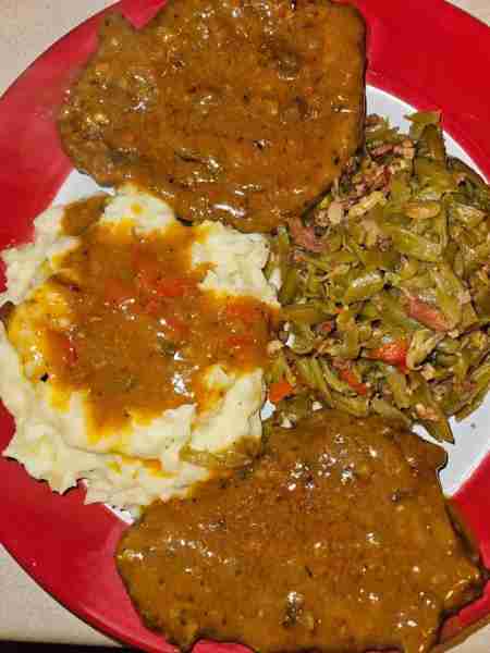 Cube steaks with gravy, homemade garlic mashed potatoes, and fried green beans with bacon, onions an...