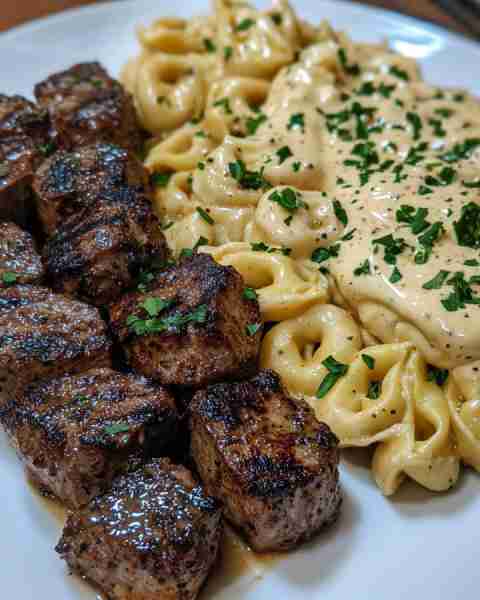 CAJUN GARLIC BUTTER STEAK BITES WITH CREAMY TORTELLINI ALFREDO Ingredients: 1 lb rib-eye or sirloin...