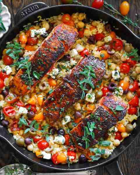 Mediterranean Salmon & Rice with Chickpeas, Cherry Tomatoes, Olives, Feta, Lemon, and Oregano. 🍅🥑...