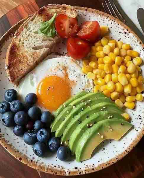 Rainbow Breakfast Bowl 🍳🥑🌽🍅🫐🍞🌿 Ingredients: 🍳 1 sunny-side-up egg 🥑 Sliced ripe avocado wit...