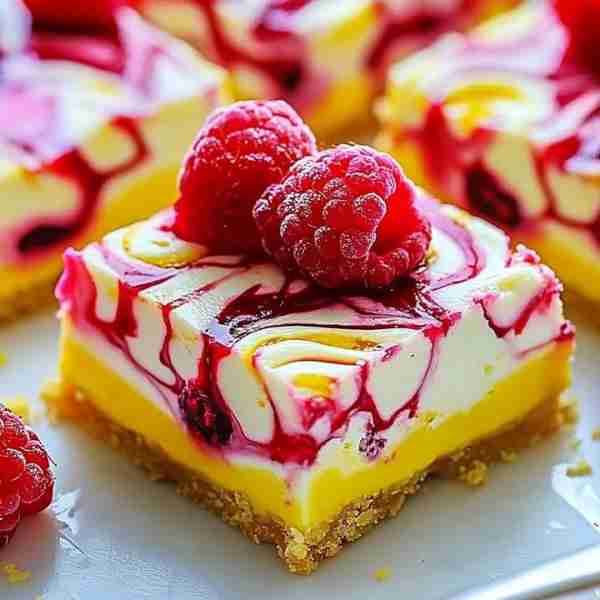 Elegant Lemon Raspberry Cheesecake Bars Ingredients: For the Crust: 1 1/2 cups graham cracker crumbs...