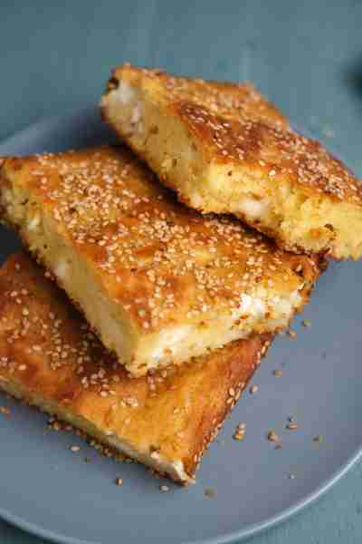 A Crustless cheese pie (No-phyllo Tiropita) with feta cheese, Greek yogurt, and sesame seeds. This d...