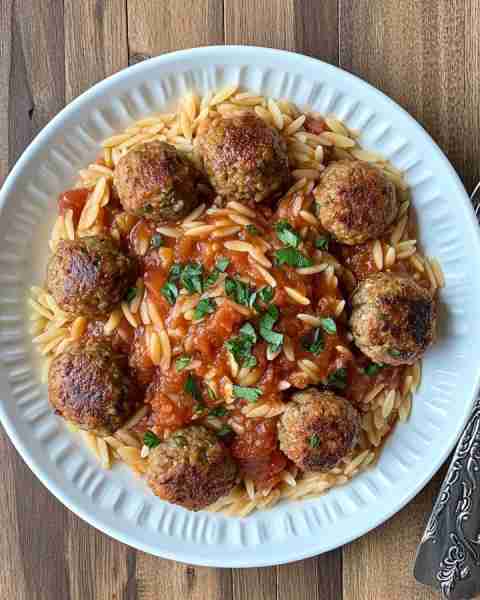 🍝🔥 Hearty Baked Meatballs with Tomato Orzo & Melty Feta 🧆🧄🍅 Prep Time: Moderate Cooking Time: M...
