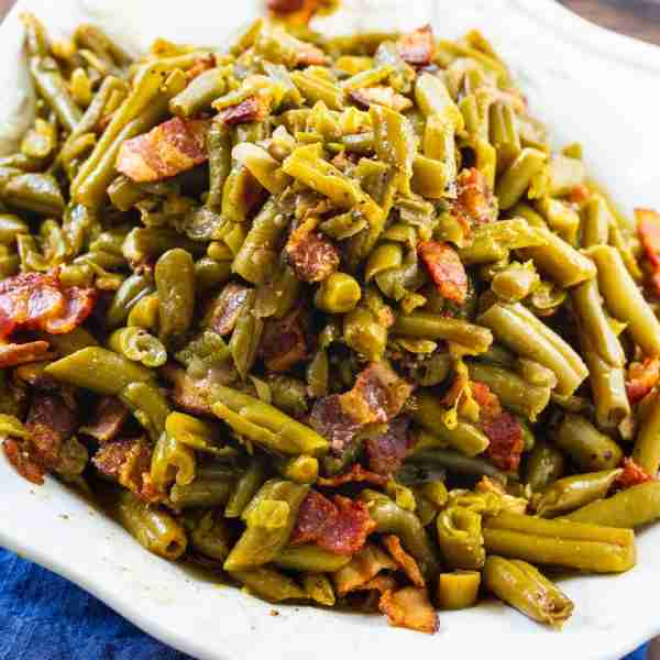 This Crock Pot Buttery Bacon Green Beans recipe turns canned beans into some of the most delicious g...