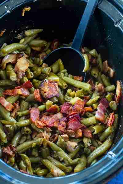 This Crock Pot Buttery Bacon Green Beans recipe turns canned beans into some of the most delicious g...