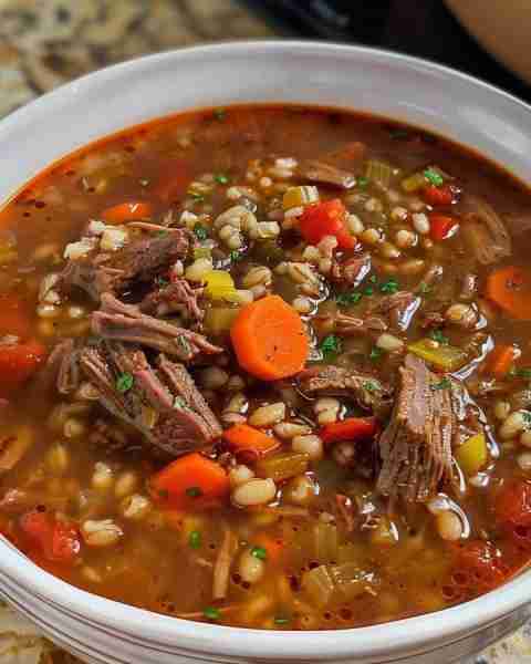 Beef Barley Soup is a delectable combination of beef, carrots, celery, onions, tomatoes, corn, and b...