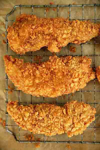 These flavorful chicken tenders are tossed in a delicious seasoning, coated in crushed saltine crack...