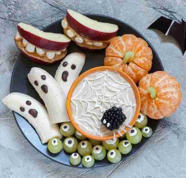 Who says Halloween treats can't be healthy and adorable? 🎃 🍌 🍊 This fruit platter is sweet, silly...