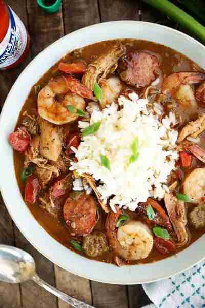 This recipe for Chicken, Sausage, and Shrimp Gumbo starts with a dark roux which gives the gumbo ton...
