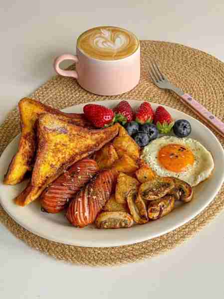 🍞🍯 Golden French toast with grilled sausages 🌭, crispy potato wedges 🥔, sautéed mushrooms 🍄, an...