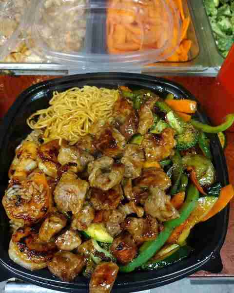 Hibachi plate loaded with steak, shrimp, noodles, and stir-fry veggies.
