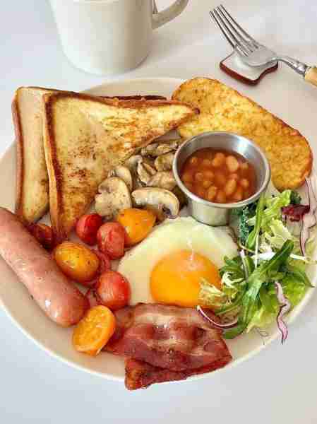 breakfast loaded with golden toast 🍞, crispy bacon 🥓, savory sausage 🌭, sunny-side egg 🍳, roaste...