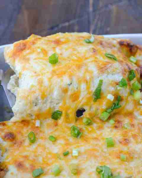 These easy Enchiladas are loaded with shredded chicken, green chiles, sour cream, and cheese!
