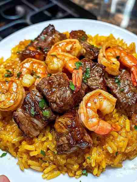 Honey Garlic Steak & Shrimp over Yellow Rice 🍤🥩 A savory and sweet combination of juicy shrimp, te...