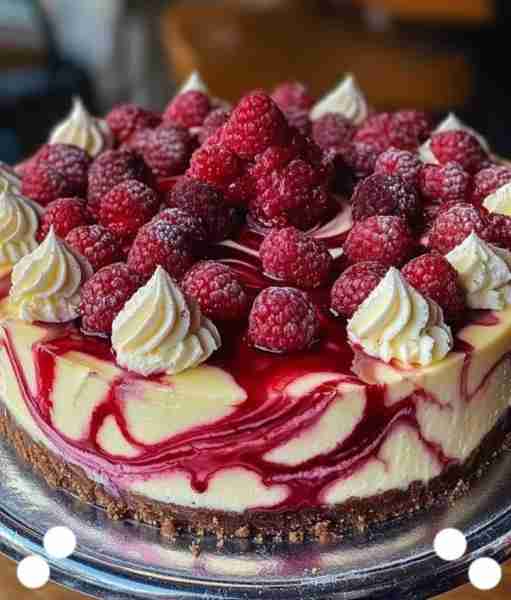 🍰 Elegant White Chocolate Raspberry Swirl Cheesecake 🍰 🍪 2 cups graham cracker crumbs 🧈 1/2 cup...