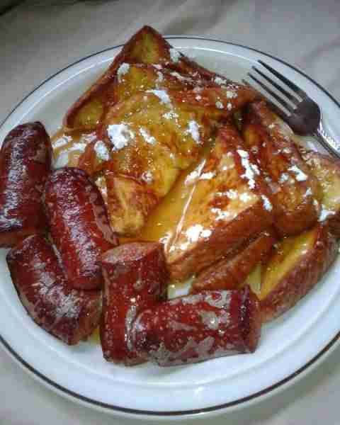 Golden French toast with syrup, powdered sugar, and sausage 😋😋😋