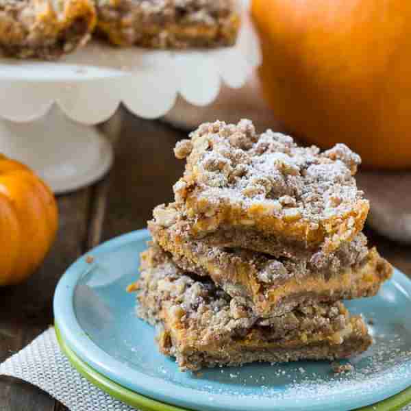 Pumpkin Spice Bars with a creamy cheesecake filling and a streusel topping with chunks of white choc...